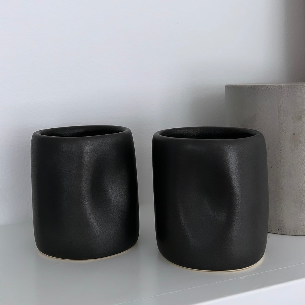 Matt black Alex Marshall tumbler on a white shelf