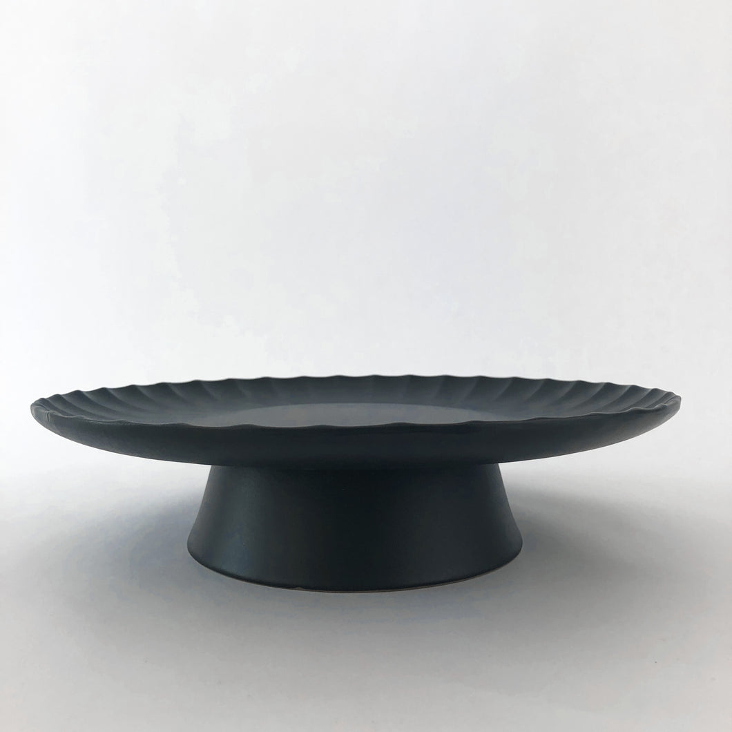 black cake stand on a white background