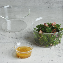 Load image into Gallery viewer, glass kinto bowl with a salad and a smaller down of dressing on a counter top
